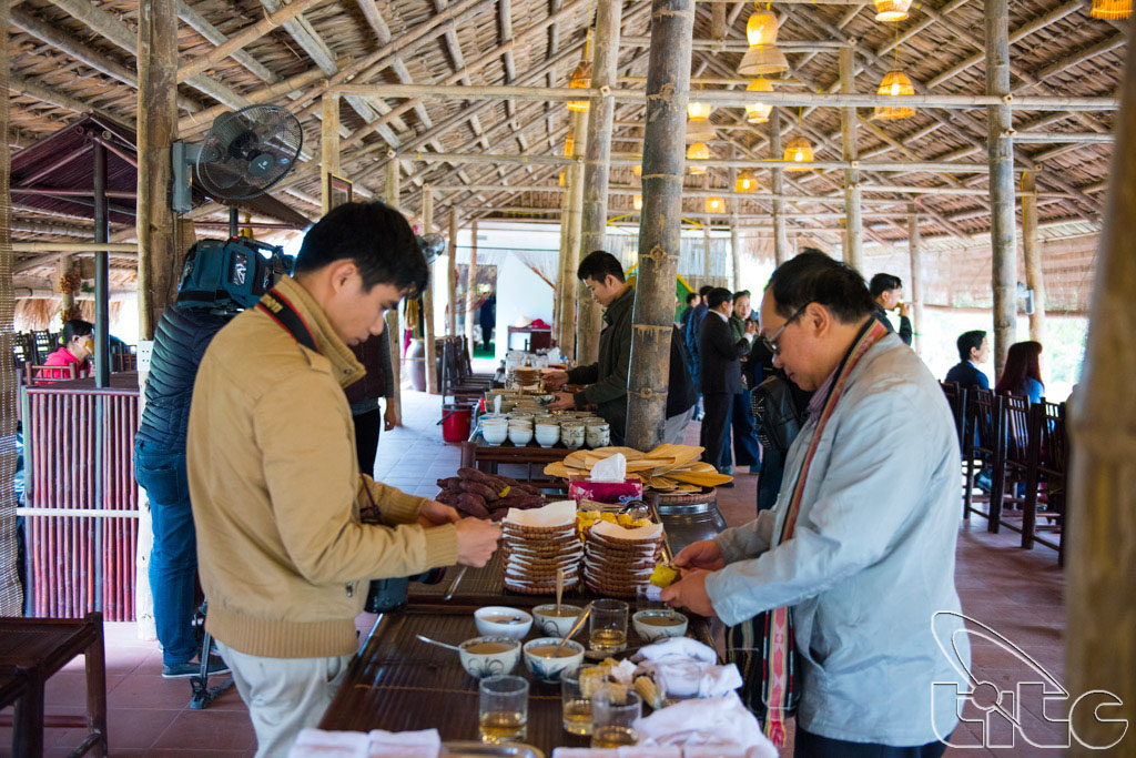 Các thành viên đoàn khảo sát thưởng thức đặc sản địa phương tại làng Yên Đức